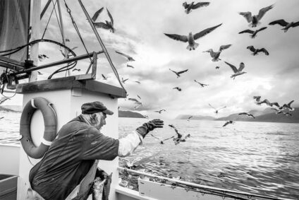 Schwarz-Weiß-Bild eines Fischers im Boot.