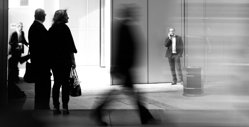 Schwarz-Weiß-Fotografie verschiedener Menschen auf der Straße.