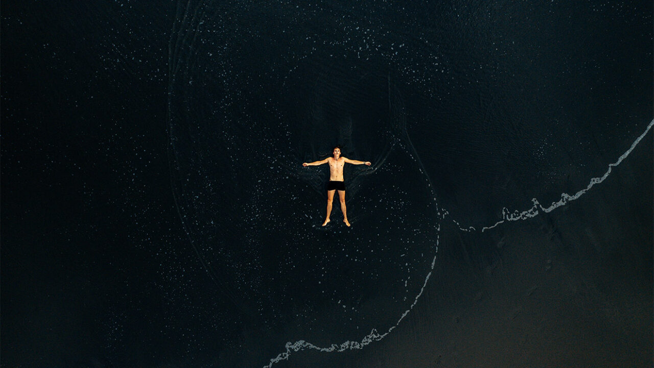 Ein Mann treibt auf dem Rücken liegend im Meer.