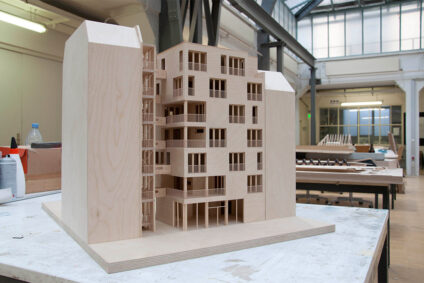 Auf einem Schreibtisch steht das Modell des Holzbaus e3.
