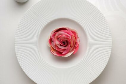 Rohkost, auf einem weißen Teller arrangiert wie eine Rosenblüte.