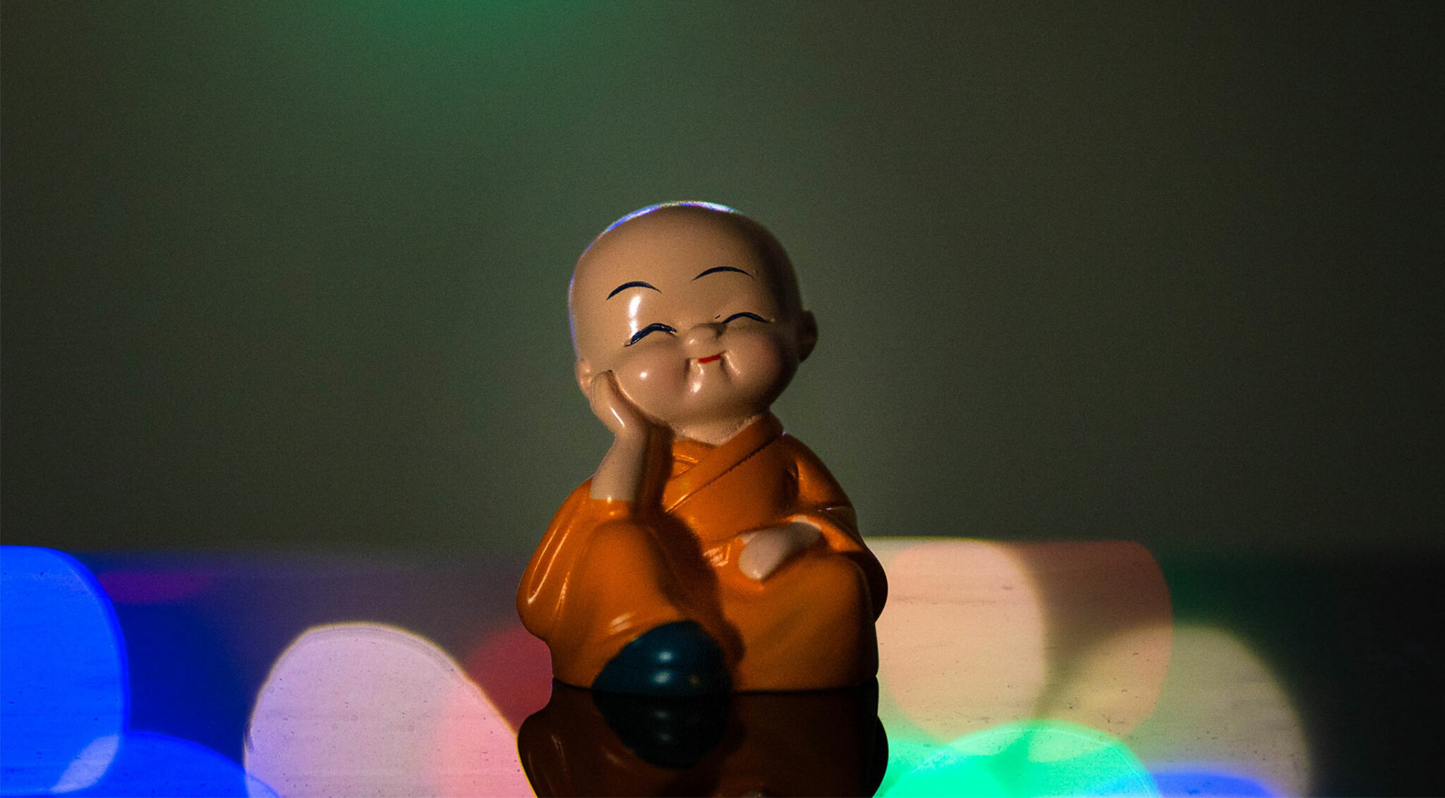 Zufrieden wirkende Figur eines asiatischen Mönches.