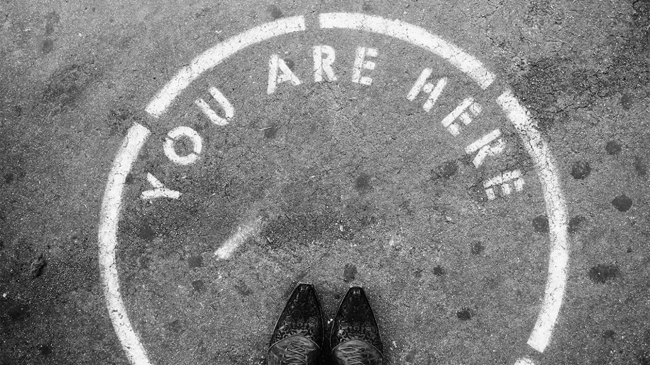 Schrift "You are here" auf einer Straße.