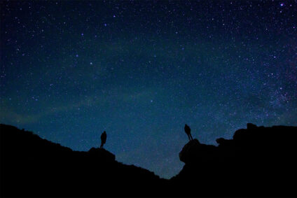 Berg Silhouette mit zwei Menschen vor dem Sternenhimmel
