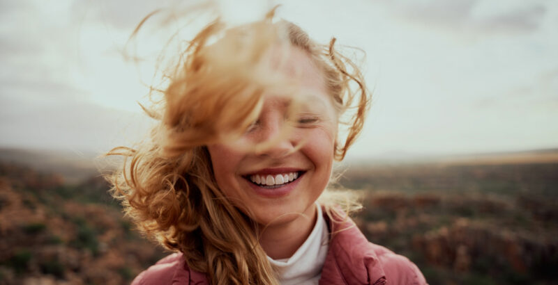 Wind bläst durch das Haar einer lachenden Frau