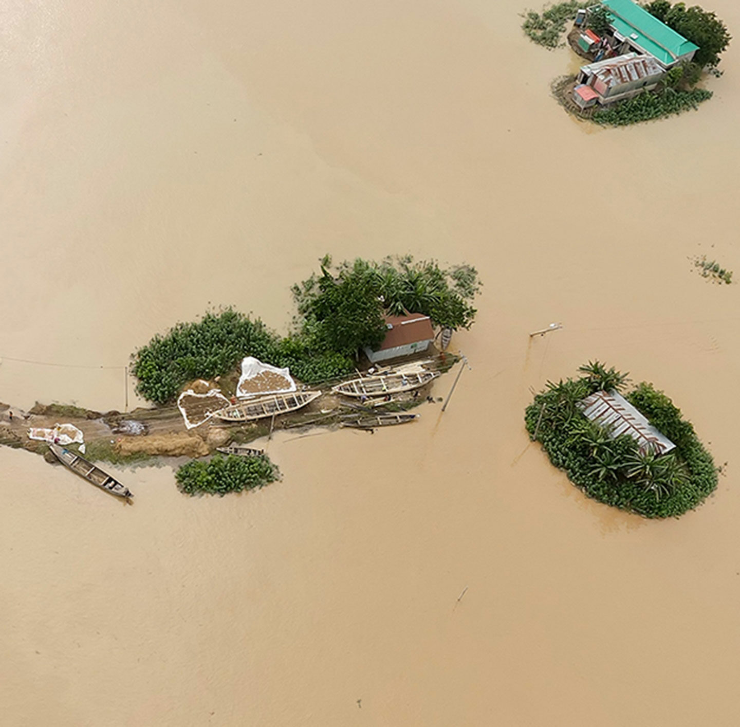 Überfluteter Landstrich mit einigen Häusern als Inseln
