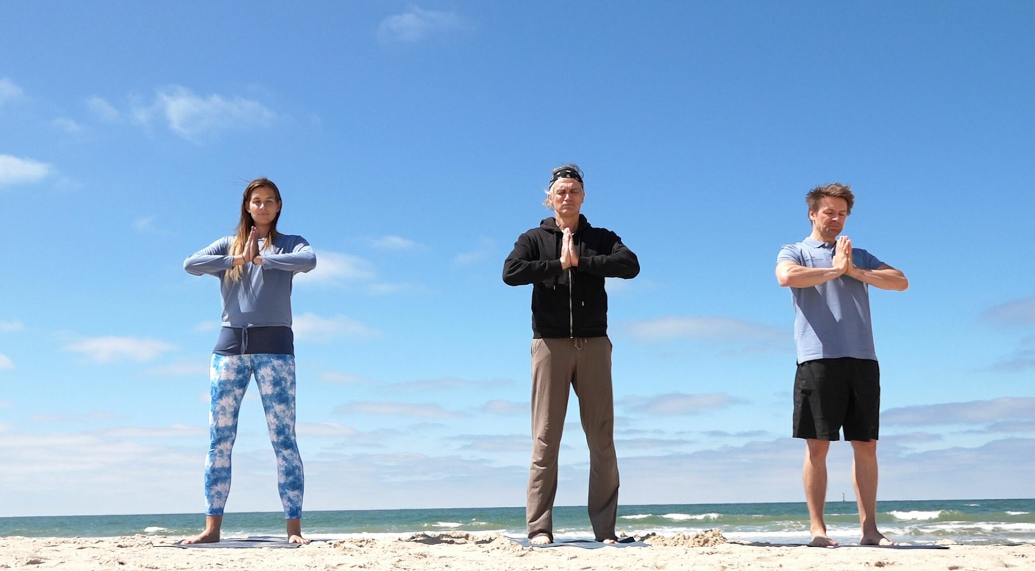 Drei Menschen beim Yoga