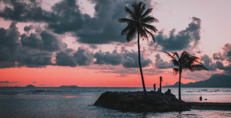 Kleine Insel mit Palmen im Sonnenuntergang