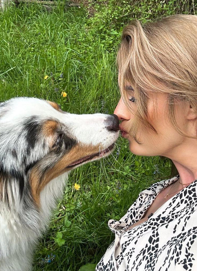 Hund küsst eine Frau auf den Mund