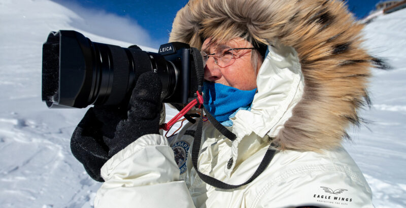 Nomi Baumgartl mit Kamera im Schnee.