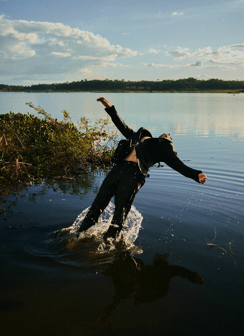 Ein Mensch lässt sich rückwärts in einen See fallen