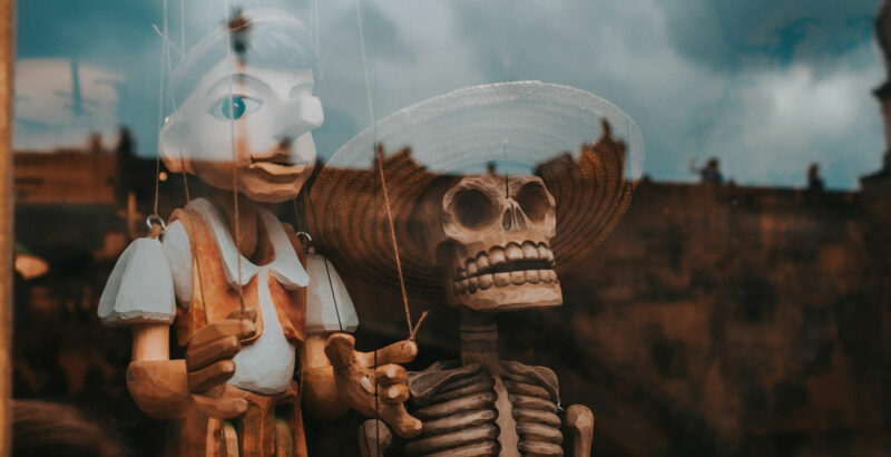 Eine Marionette und ein Totenkopf in einem Schaufenster
