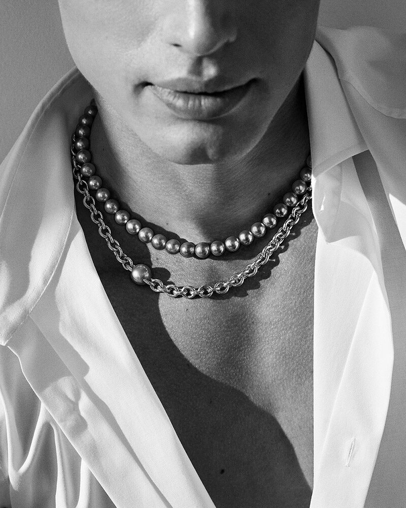 Schwarz weiss Mann mit Perlenschmuck