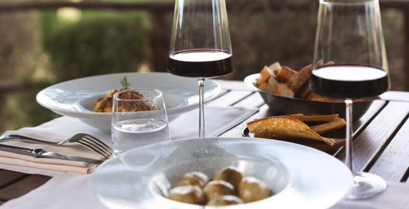 Gedeckter Tisch mit Rotweingläsern und kleinen Köstlichkeiten – Gnocchi and Pappardelle