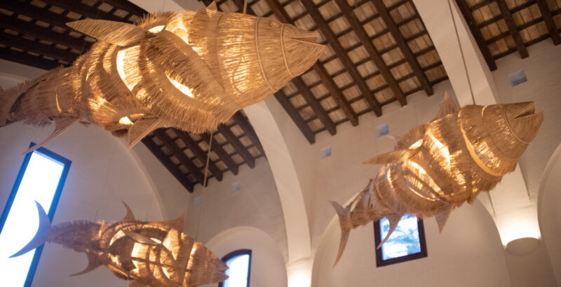 Geflochtene Skulpturen in Form von Fischen hängen von der Decke im DAIA Slow Beach Hotel Conil