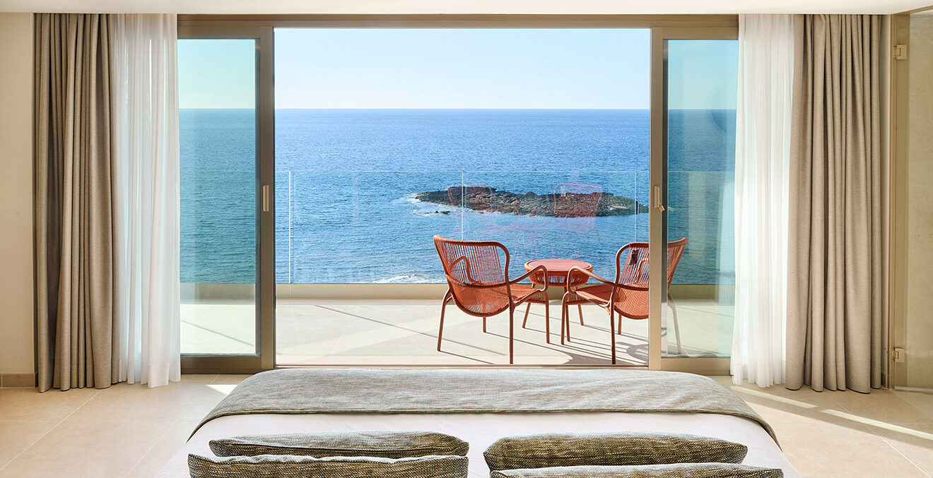 Blick aus einer geöffneten Balkontür eines Zimmer des Hotels Hotel „Iberostar Selection Es Trenc" auf das Meer