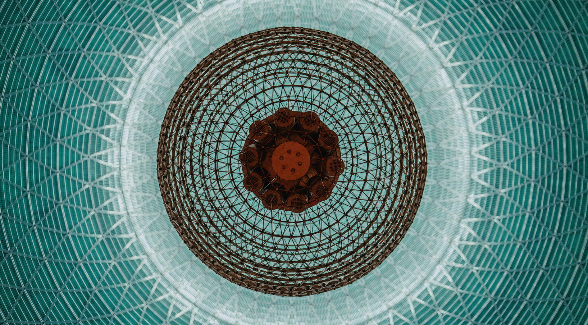 Symmetrisches Mandala mit zentralem Auge auf türkisfarbenem Mosaikhintergrund