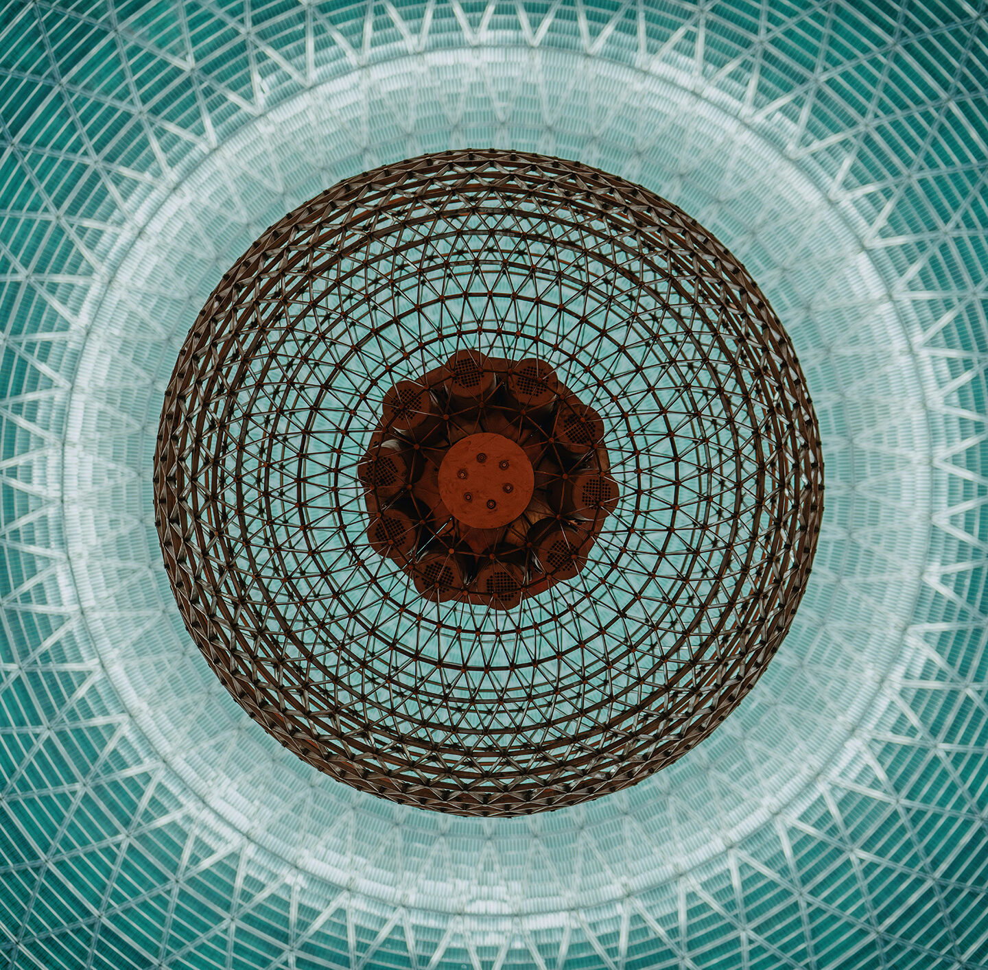Symmetrisches Mandala mit zentralem Auge auf türkisfarbenem Mosaikhintergrund