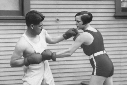 Mann und Frauen beim Boxtraining mit Handschuhen in sportlicher Pose