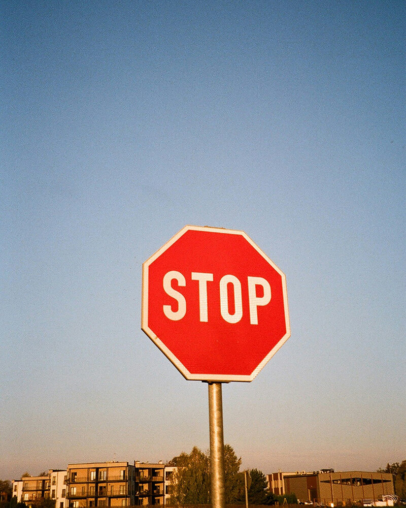Rotes Stoppschild vor blauem Himmel in trockener Wüstenlandschaft
