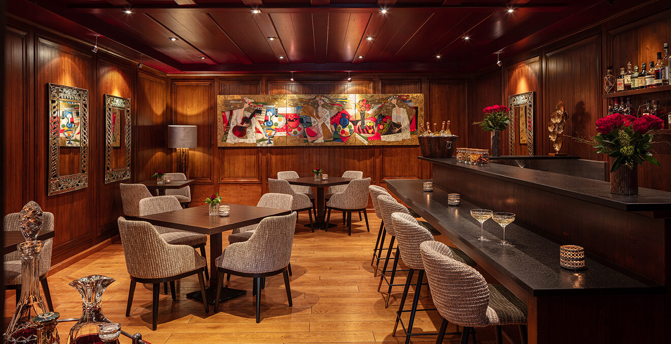 Bar im Hotel mit beigen Stühlen und Holzvertäfelung.