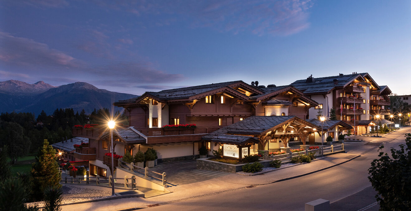 Blick auf das verschneite Hotel Golf Guarda in der Abenddämmerung.