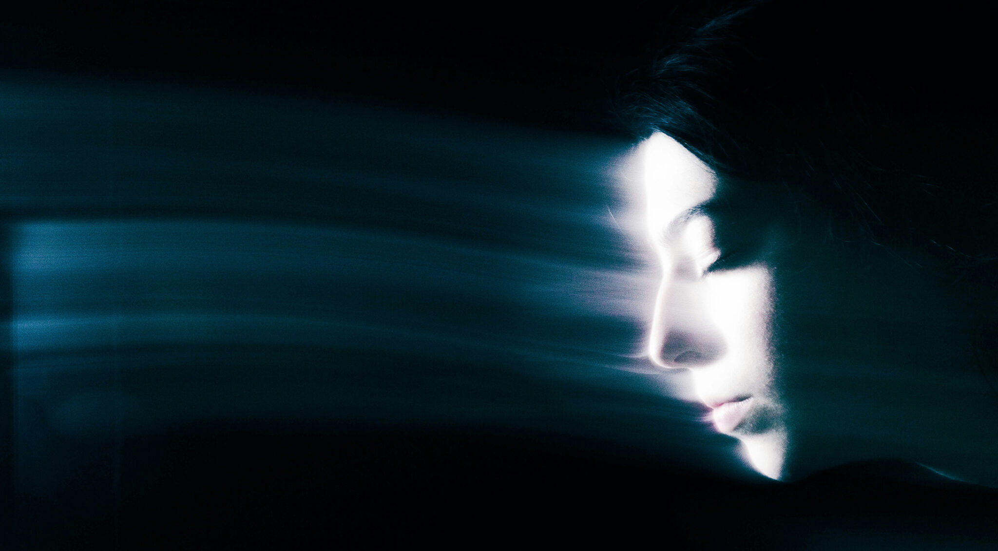 Abstraktes, dunkles Lichtmotiv in Blautönen mit einer verschwommenen menschlichen Silhouette, die Licht und Schatten symbolisiert.