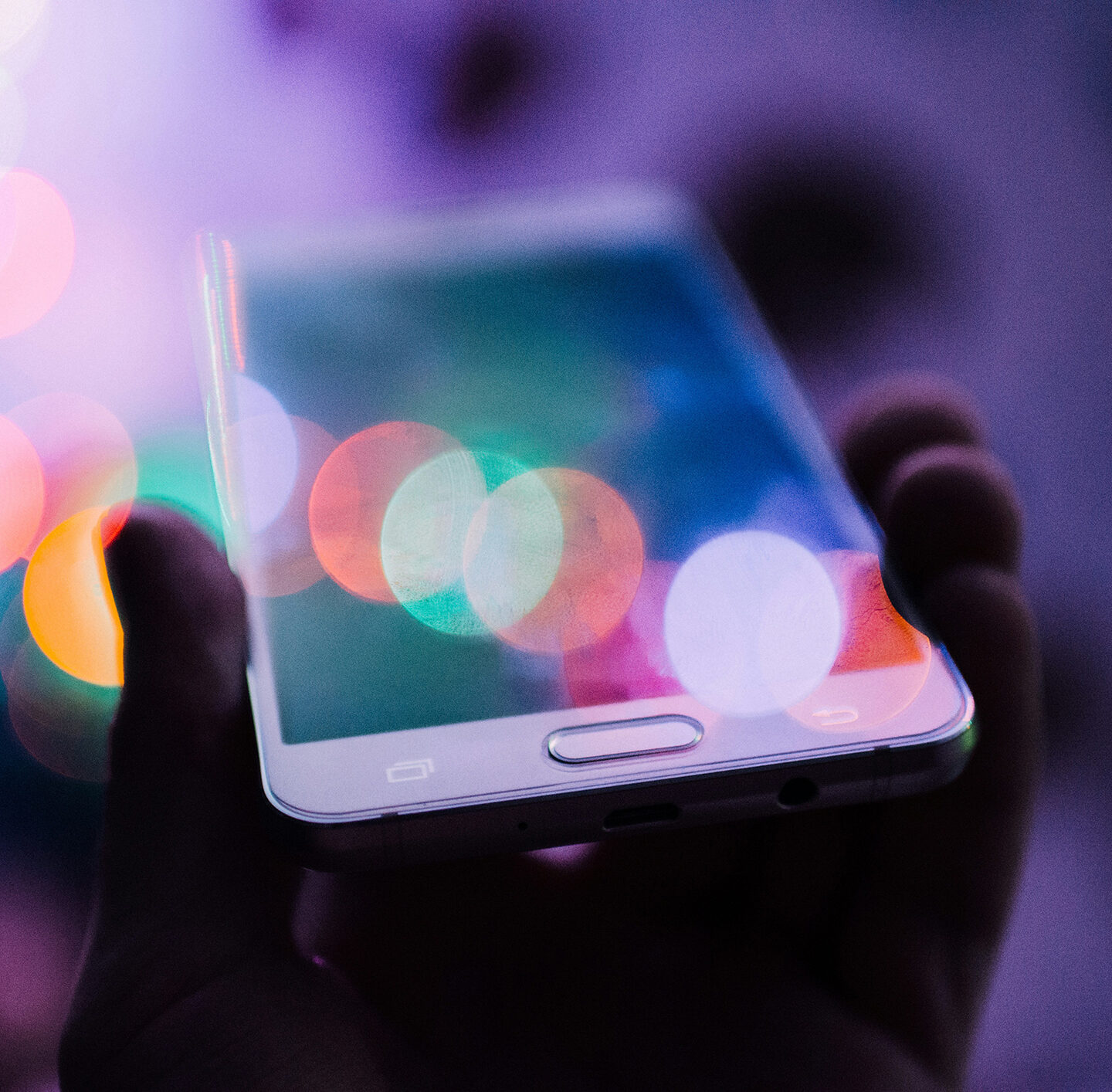 Unscharfe, bunte Lichtkreise auf dunklem Hintergrund symbolisieren digitale Ablenkung und Reizüberflutung durch Bildschirme.