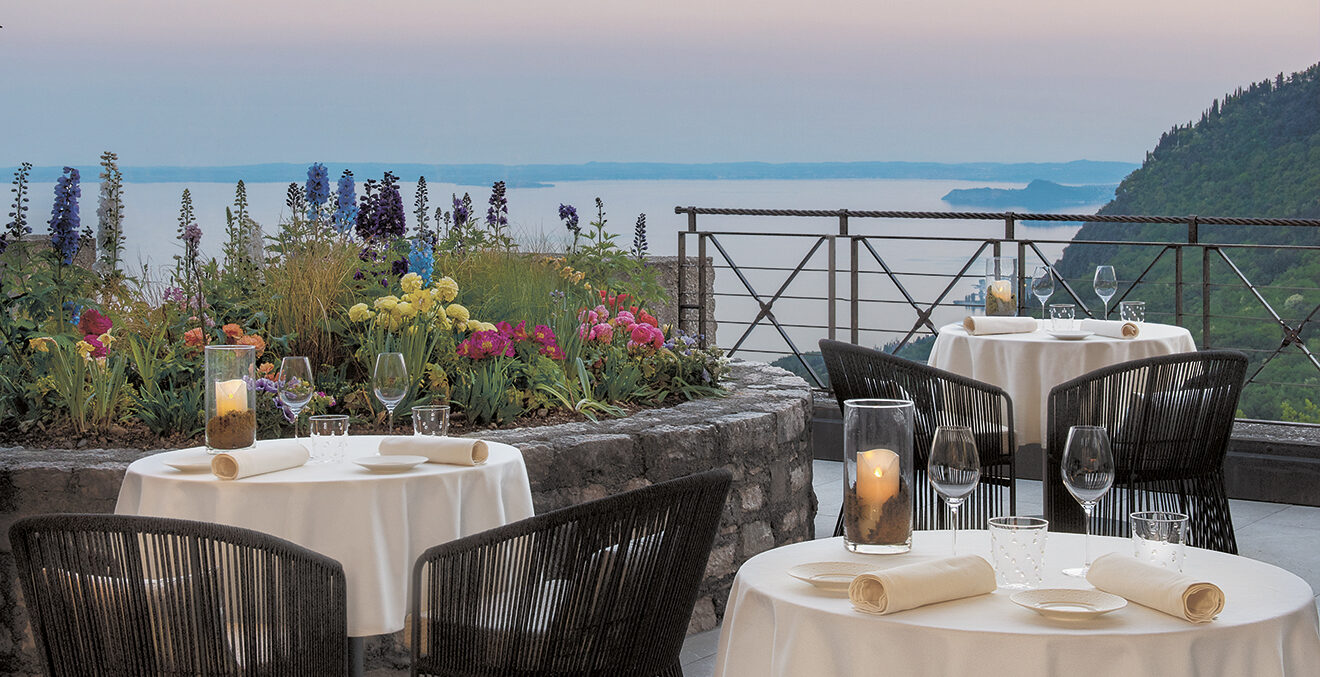 Terrasse des Lefay Resorts mit Tischen und Blick auf den Gardasee.