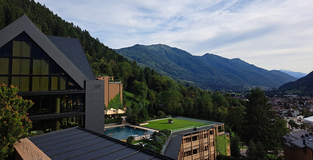 Lefay Resort eingebettet in grüne Hänge oberhalb des Gardasees mit moderner Architektur und großen Glasfronten.
