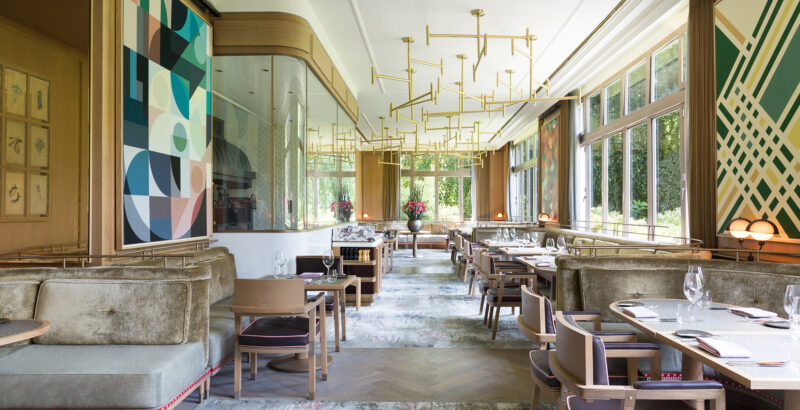 Designer-Restaurant mit modernem Interieur, hellen Farben und großen Fenstern.