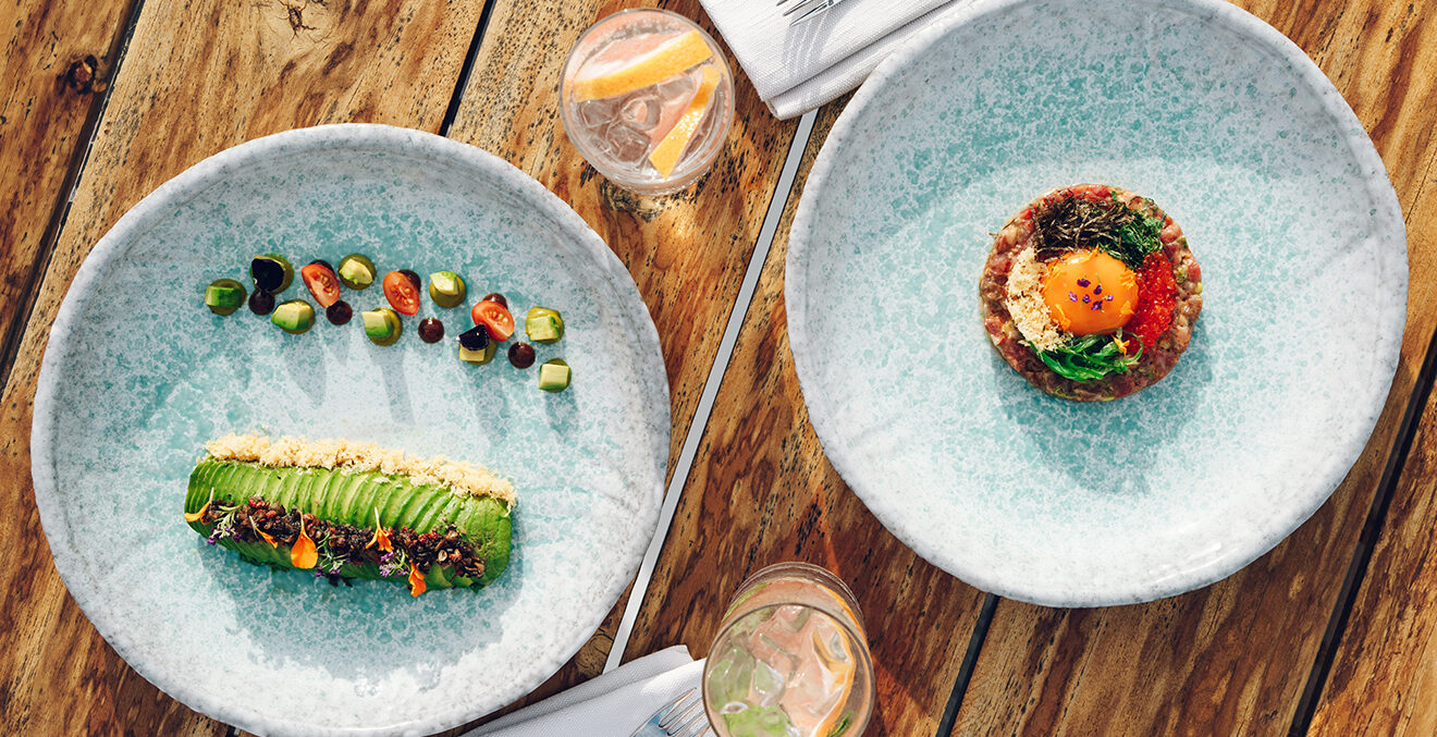 Zwei hellblaue Teller mit bunten Speisen.