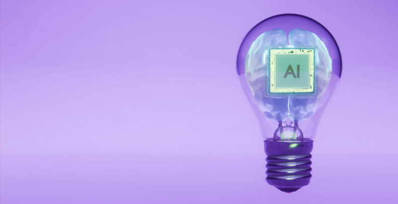 Glühbirne, in deren Innerem eine grüne Landschaft mit Bergen dargestellt ist.