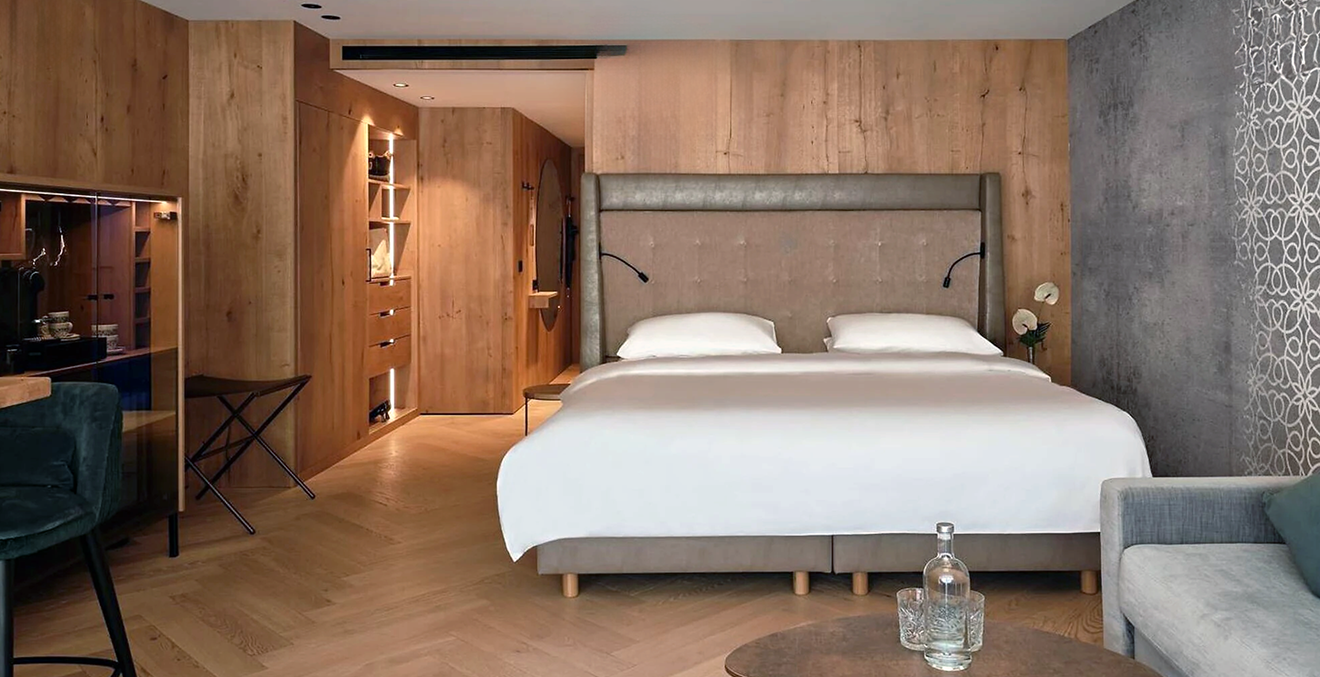 Hotelzimmer mit holzvertäfelten Wänden und einem großen Bett.