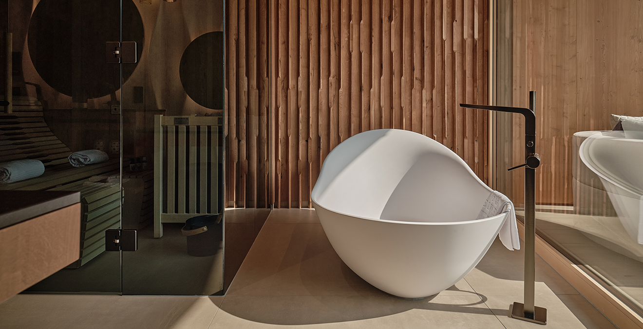 Frei stehende Badewanne vor Panoramafenster.