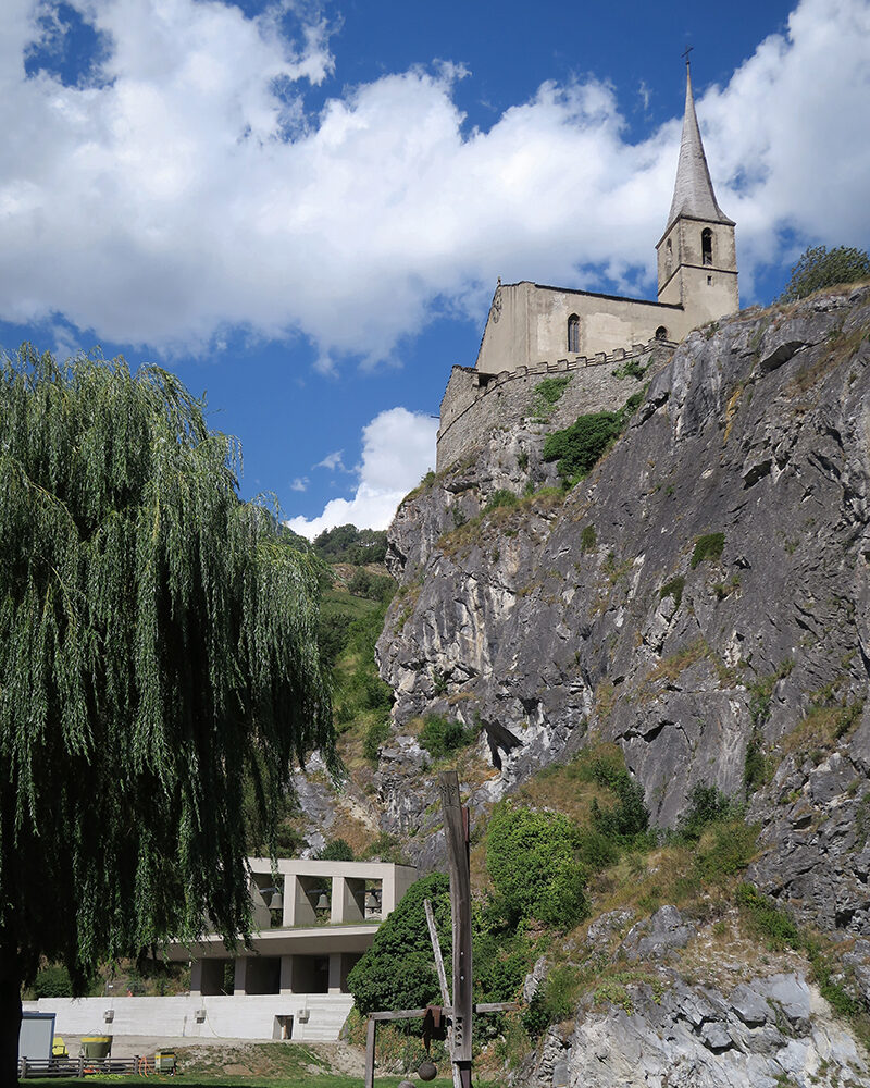 Berglandschaft mit einer kleinen historischen Siedlung und Kirche.