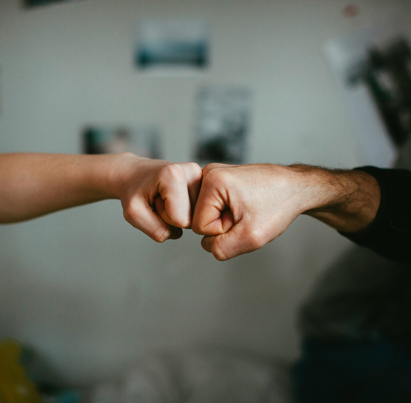 Zwei Personen stoßen zur Begrüßung oder Zusammenarbeit ihre Fäuste an.