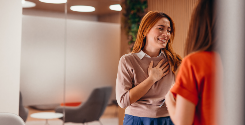 Zwei Frauen unterhalten sich in einer büroähnlichen Umgebung.