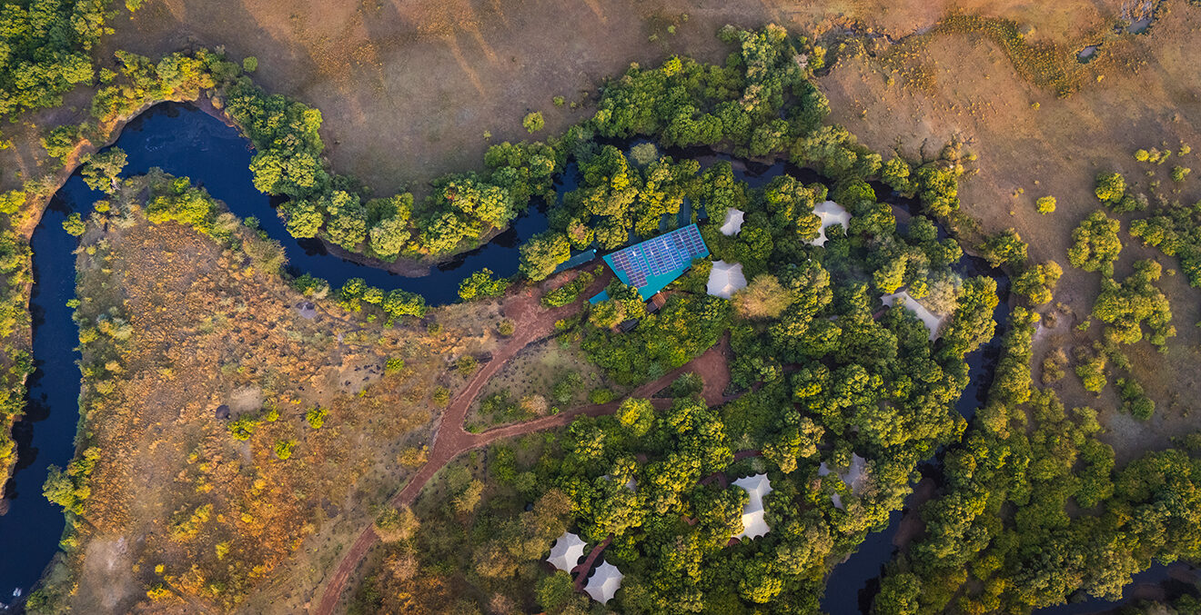 Luftaufnahme einer weiten Landschaft mit Flussarmen und grünen Vegetationsflächen.