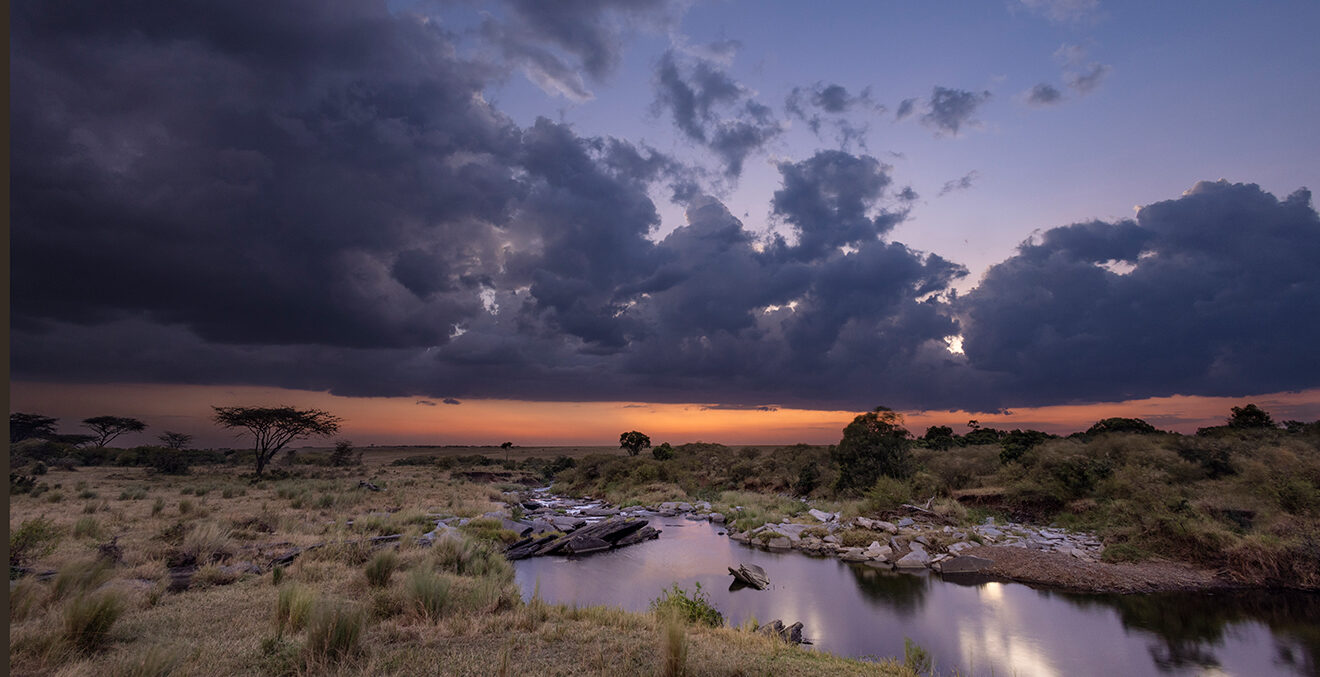 Weite Landschaft mit Flussarmen und grünen Vegetationsflächen im der Abenddämmerung.