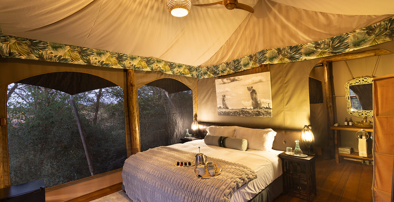 Blick in ein Schlafzimmer mit großem Bett des Great Plains-Mara TotoTreeCamp.