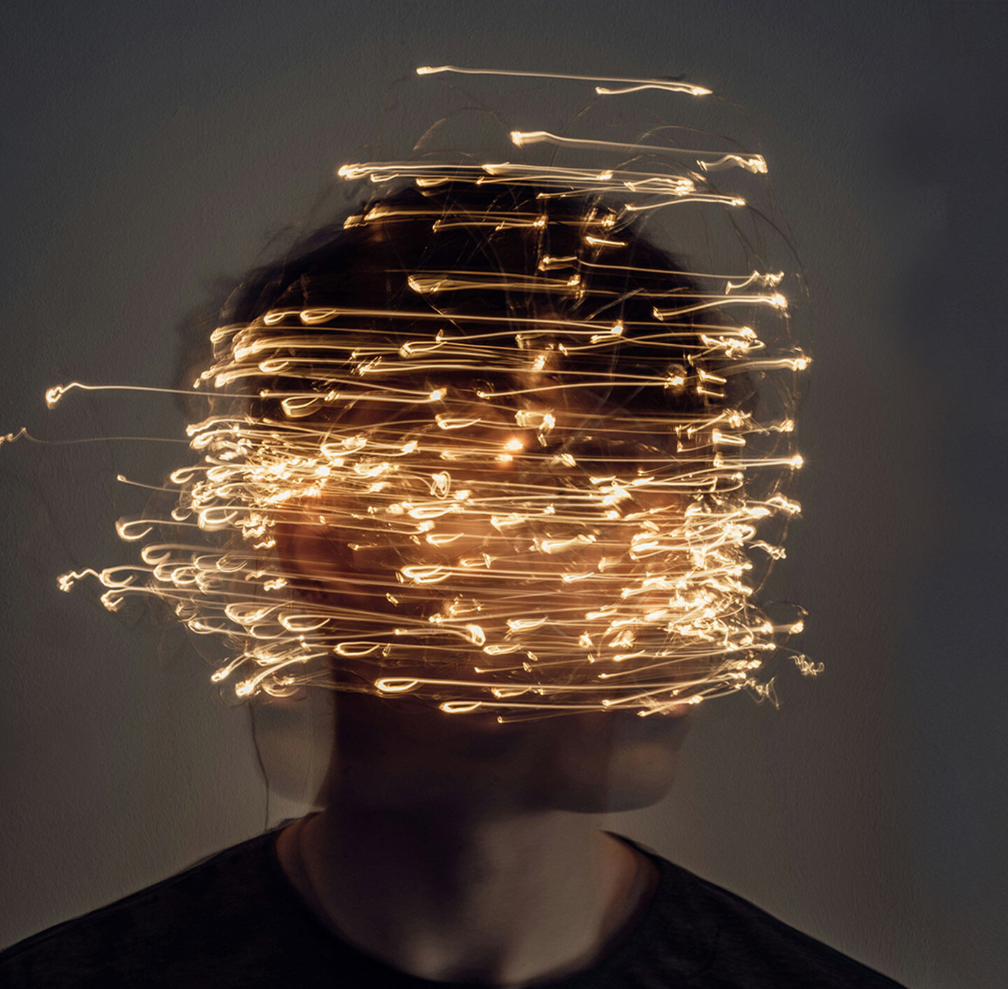 Porträt einer Person mit goldenen Lichtspuren vor dem Gesicht.