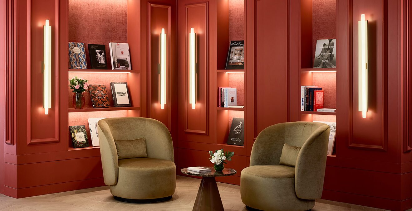 Die Lobby des Hotel NH Collection Paris Ponthieu Champs-Élysées mit roter Wandvertäfelung und hellen Sesseln.