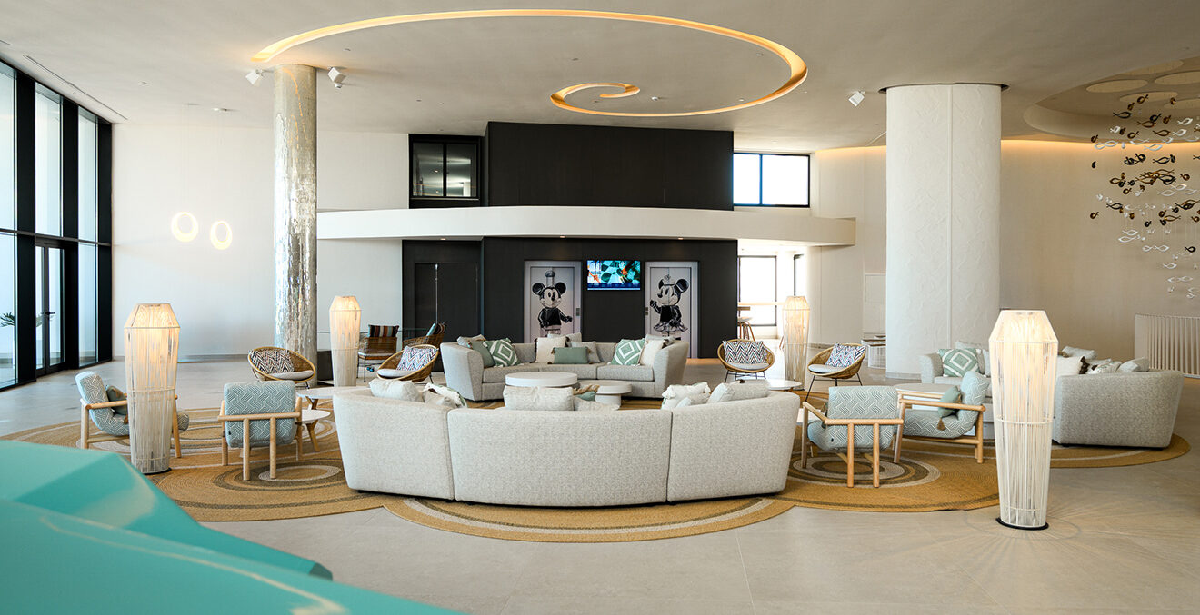 Loungebereich im Hotel Amàre mit weißen Sofas, Bodenlampen und Lautsprechern.