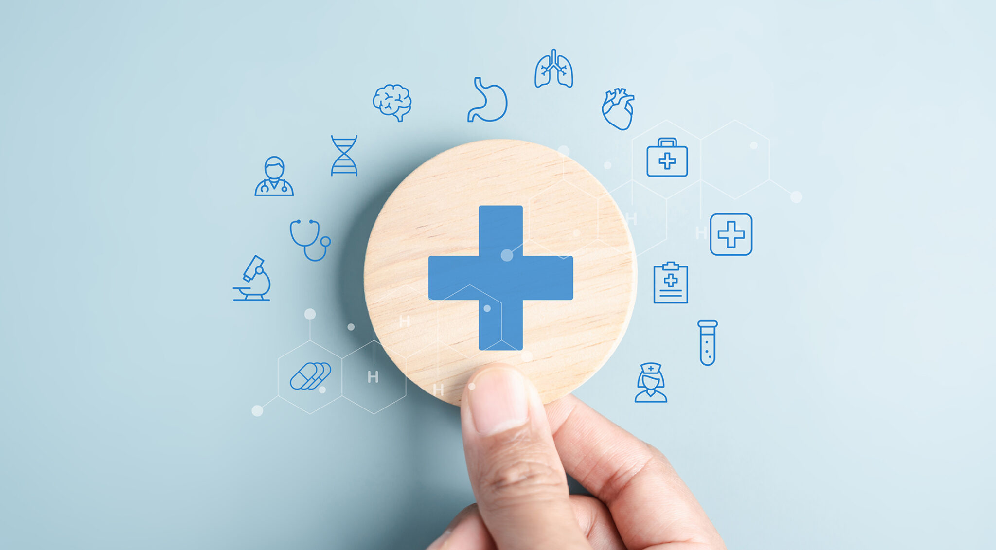 Illustration auf hellblauem Hintergrund: In der Mitte befindet sich ein großer runder Button mit einem blauen medizinischen Kreuz. Um den Kreis sind zahlreiche blaue, handgezeichnete Symbole aus dem Gesundheitswesen verteilt, darunter Herz, Gehirn, Spritze, Stethoskop, Tabletten, Krankenwagen, Rollstuhl, Blutstropfen und weitere medizinische Piktogramme.