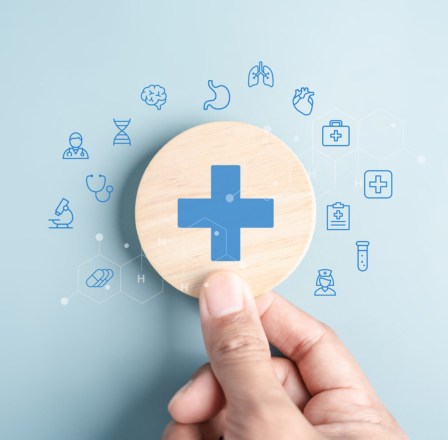 Illustration auf hellblauem Hintergrund: In der Mitte befindet sich ein großer runder Button mit einem blauen medizinischen Kreuz. Um den Kreis sind zahlreiche blaue, handgezeichnete Symbole aus dem Gesundheitswesen verteilt, darunter Herz, Gehirn, Spritze, Stethoskop, Tabletten, Krankenwagen, Rollstuhl, Blutstropfen und weitere medizinische Piktogramme.