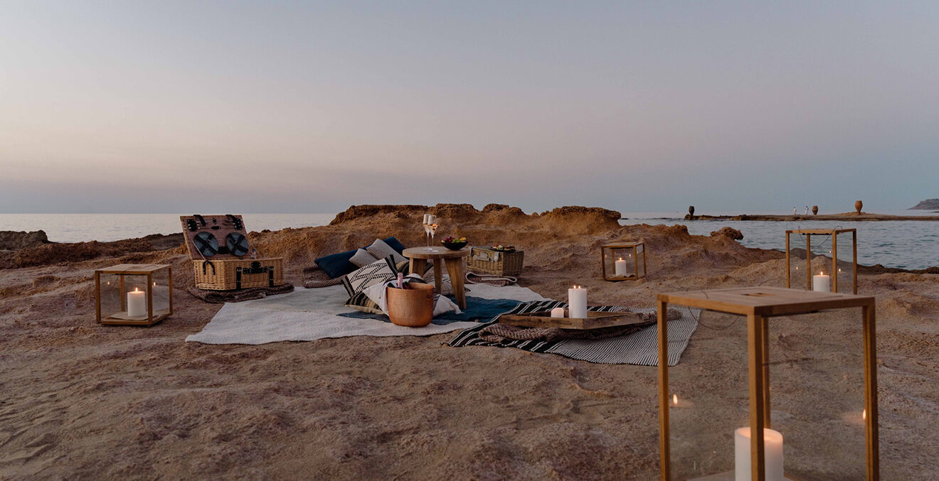 Picknick am Strand in der Abenddämmerung mit Kerzenlicht.