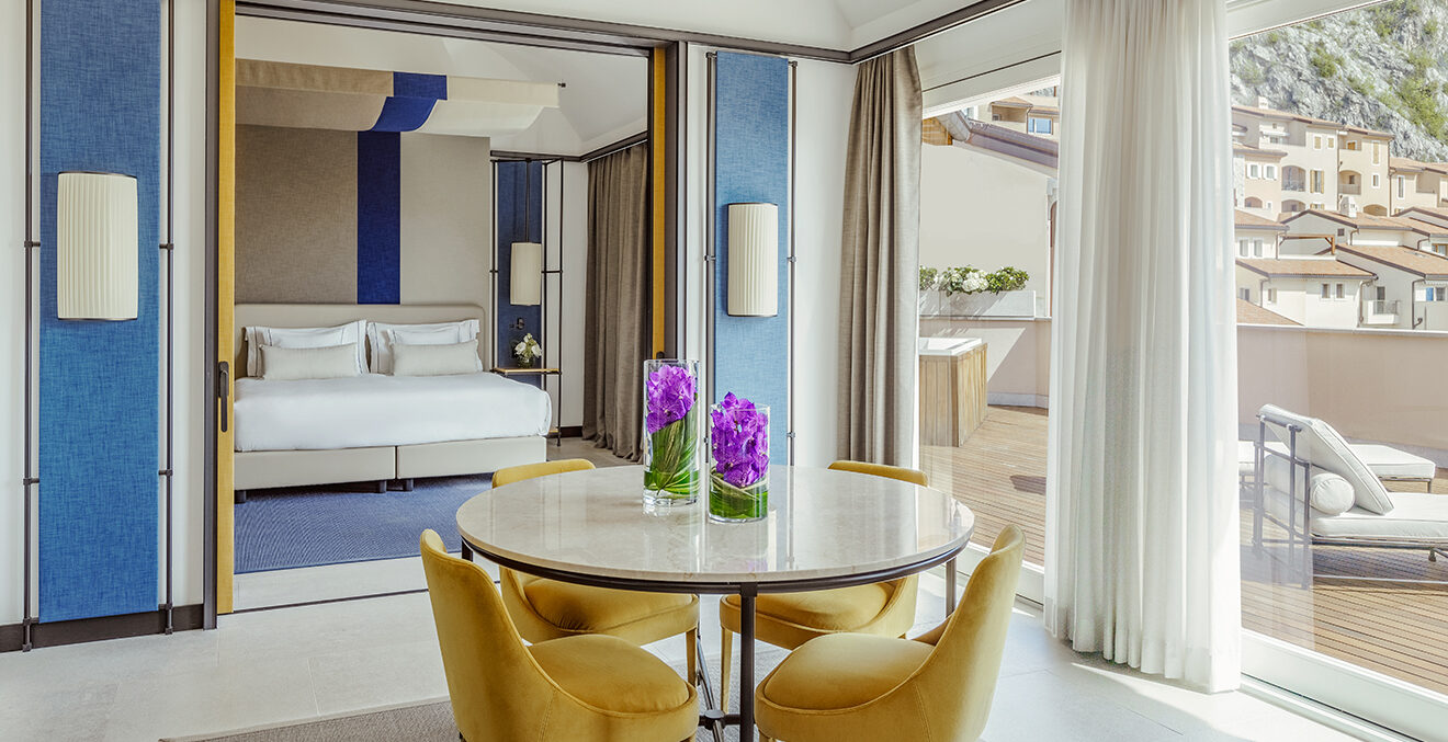 Hotelzimmer in blau-weiß gehalten mit großem Fenster.
