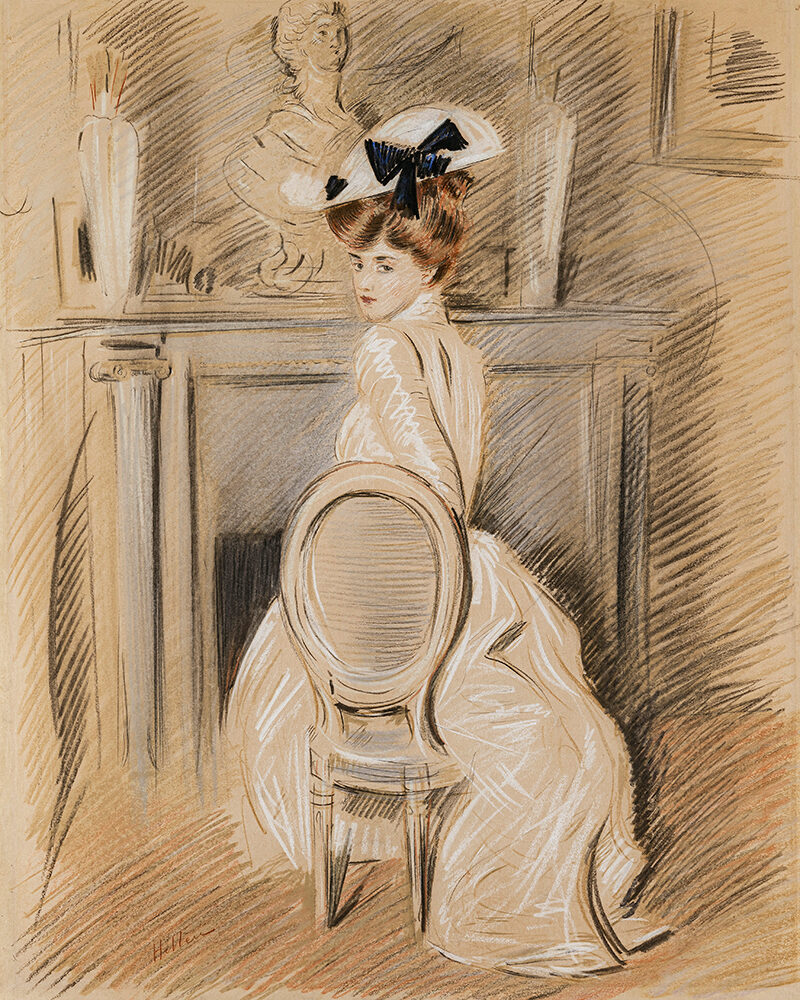 Alice Helleu sitzt in einem weißen Kleid und mit elegantem Hut seitlich auf einem Stuhl