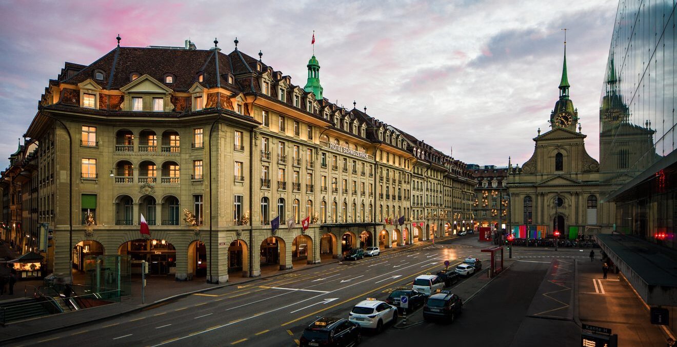 Außenansicht des Hotel Schweizerhof Bern am Bahnhofplatz in der Abenddämmerung